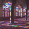 نمای شگفتانگیز از نمازخانه مسجد نصیرالملک (مسجد صورتی). نور خورشید صبحگاهی از میان شیشههای رنگی روی ستونها، دیوار و کف منعکس میشود.