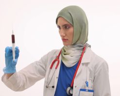 ویدیوی استوک از زنی با اعتماد به نفس و حجاب که سرنگی با مایع قرمز آماده می‌کند
