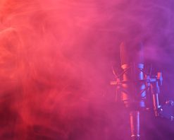 میکروفون حرفه‌ای در دود صورتی روی پس‌زمینه مشکی. ویدیوی استوک