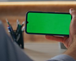 فوتیج ماکت حرفه‌ای تلفن در دست در نمای نزدیک دفتر. ویدیوی استوک 4K از رئیس در حال تماشای وبینار