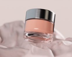 شیشه شیشه‌ای چرخان کرم لوکس روی پارچه‌ای نرم و صورتی. ثبت ظرافت و زیبایی در محیطی آرام. انیمیشن سه‌بعدی، ویدیوی استوک