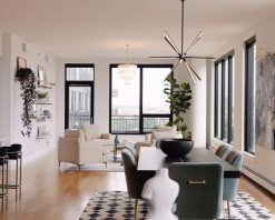 از یک آپارتمان مرتفع که یک میز ناهارخوری در پیش‌زمینه و یک فضای نشیمن با چهار صندلی سفید را نشان می‌دهد، ویدیوی استوک