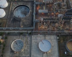 نمای هوایی از صنعت نفت و گاز، مخزن ذخیره نفت کارخانه پالایشگاه و خط لوله فولادی در شب، ویدیوی استوک 4K