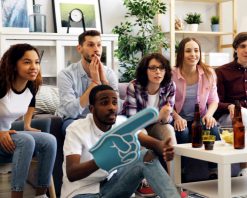 جوانان خوشحال از تماشای بازی‌های ورزشی در تلویزیون خانه لذت می‌برند و ویدیوی استوک 4K را در آغوش می‌گیرند.