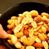 mrmix.com_Picking almond form mixed nuts in bowl stock video